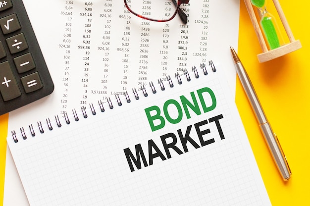 Premium Photo | Writing text BOND MARKET on white notepad paper, green and black letters, yellow background.